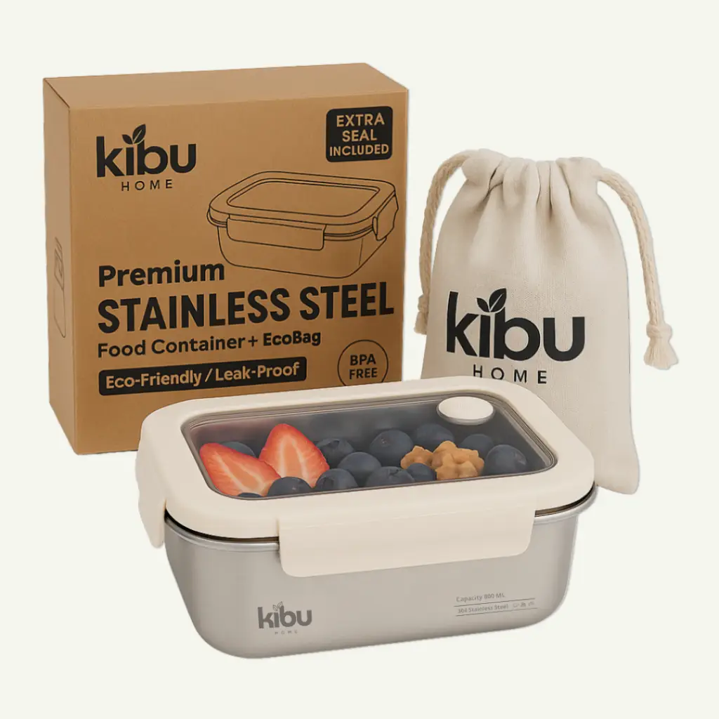 A stainless steel food container with a clear lid, accompanied by a packaging box and a canvas EcoBag, showcasing berries and nuts inside.
